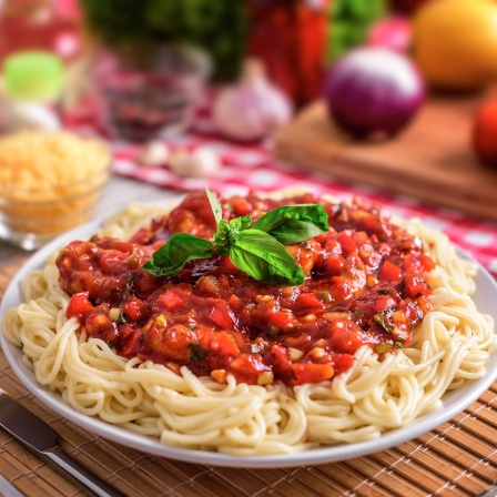 Teller voll Spaghetti mit Tomatensoße: Spaghetti mit Tomaten, Basilikum und Parmesan ist das Symbol italienischer Esskultur. Nudeln sind keine italienische Erfindung, doch hier wurden sie vom regionalen zum nationalen und heute globalen Erfolgsmodell.