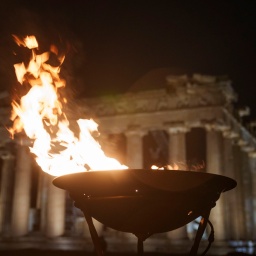 19.04.2024, Griechenland, Athen: Ein Kessel mit dem olympischen Feuer brennt vor dem antiken Parthenon-Tempel auf dem Akropolis-Hügel