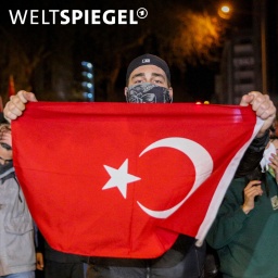 Demonstrant hält Türkei-Flagge hoch