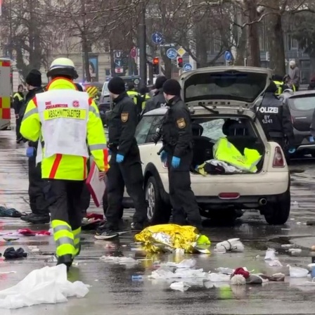 Rettungskräfte stehen am Einsatzort, nachdem ein Auto in der Münchner Innenstadt in eine Menschenmenge gefahren ist.