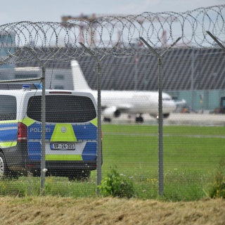  Eine Patrouille der Polizei am Stuttgarter Flughafen hinter einem Zaun.