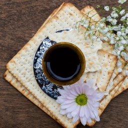 Brote, Wein und Blumen liegen auf einem Tisch