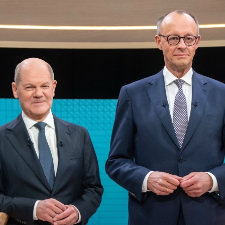 Bundeskanzler Olaf Scholz (SPD, l), steht neben Friedrich Merz, Unions Kanzlerkandidat und CDU Bundesvorsitzender, während dem TV-Duell von ARD und ZDF