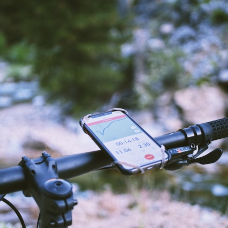 An einem Fahrradlenkrad hilft bei der Orientierung eine Handyapp.