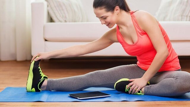 Eine Frau trainiert mit einer Fitness-App (Tablet)