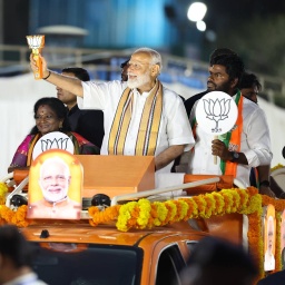Der indische Premierminister Narendra Modi steht in einem offenen Auto im Rahmen seines Wahlkampfes.