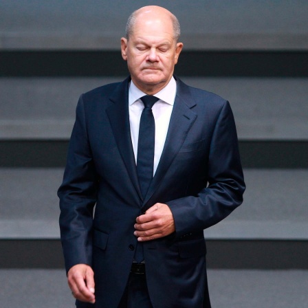 Bundeskanzler Olaf Scholz (SPD) mit geschlossenen Augen im Bundestag.