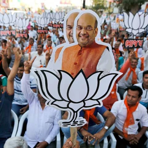 Wahlen in Indien - Unterstützer der regierenden indischen Bharatiya Janata Party (BJP) halten Ausschnitte von Parteichef Amit Shah bei einer öffentlichen Kundgebung in die Höhe
