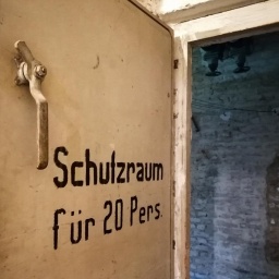 "Schutzraum für 20 Pers." steht auf einer Stahltür im Keller eines Hauses im Frankfurter Stadtteil Ginnheim. Derartige Schutzräume sollten der Bevölkerung im Zweiten Weltkrieg und im sog. Kalten Krieg Schutz insb. vor Luftangriffen bieten.