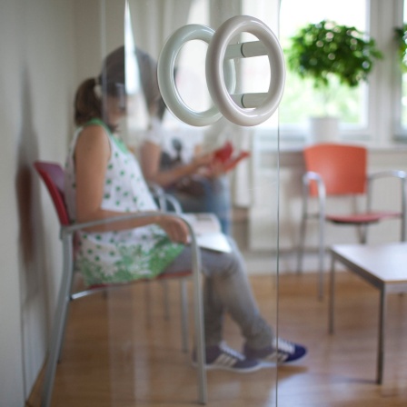 Frau sitzt in einem Wartezimmer