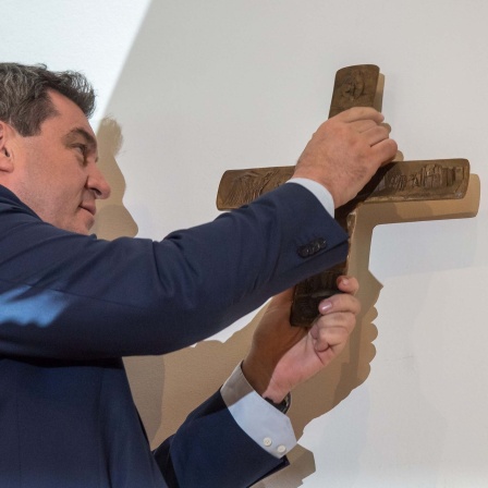 Markus Söder, Bayerischer Ministerpräsident (CSU), hängt im Eingangsbereich der bayerischen Staatskanzlei ein Kreuz auf (2018).