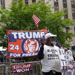 New York, schwarze Unterstützer von Trump "Blacks for Trump" stehen mit einer Flagge "Trump for President 24" vor dem Strafgericht in Manhatten © IMAGO/ZUMA Press Wire 