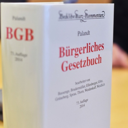 An der Richterbank eines Sitzungssaals beim Oberlandesgericht (OLG) Karlsruhe (Baden-Württemberg) sitzt am 12.09.2014 ein Richter mit Richterrobe, davor steht ein Bürgerliches Gesetzbuch