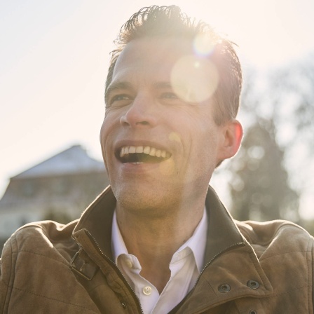 Wissenschaftsjournalist Bas Kast lacht, im Hintergrund scheint die Sonne. In SWR1 Leute spricht der Erfolgsautor von &#034;Ernährungskompass&#034; darüber, wie man sein inneres Gleichgewicht finden kann. Das verrät er in seinem Buch &#034;Kompass für die Seele&#034;.