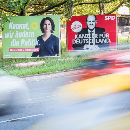 Autos fahren am Morgen an den Wahlplakaten von Bündnis 90/Die Grünen (l-r) mit Kanzlerkandidatin Annalena Baerbock, SPD mit Kanzlerkandidaten Olaf Scholz und CDU mit Kanzlerkandidaten Armin Laschet vorbei.