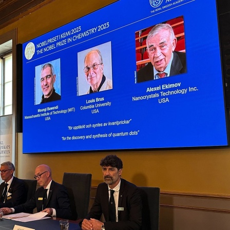 Während der Bekanntgabe des Nobelpreises für Chemie sind auf einem Bildschirm die Porträts der Wissenschaftler Moungi Bawendi (l-r), Louis Brus und Alexei Ekimov zu sehen.