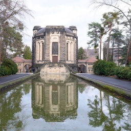 Das Krematorium Dresden-Tolkewitz spiegelt sich in einem Wasserbecken. 