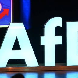 Das Logo der Partei AfD steht bei einer Wahlkampfkundgebung in der Donauhalle