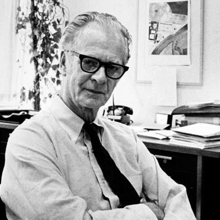 Schwarzweißaufnahme von B. F. Skinner in lockerer Pose in seinem Büro.