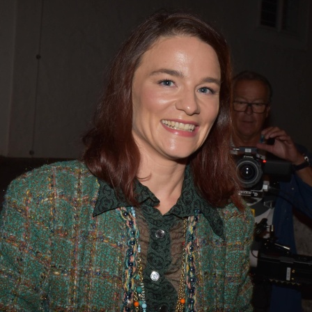Die Schauspielerin Valérie Pachner bei der Premierenfeier von "Jedermann" bei den Salzburger Festspielen. Sie trägt einen grünen Hosenanzug und lacht in die Kamera.