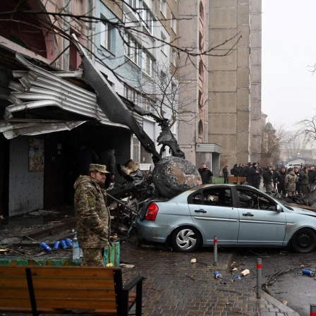 Kiew, Browary: Bei einem Hubschrauberabsturz in der Nähe eines Kindergartens sind mindestens 16 Menschen ums Leben gekommen. Unter ihnen der Innenminister Monastyrskyj. Menschen stehen am Unglücksort. 

