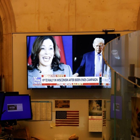 Auf einem TV-Bildschirm sind Kamala Harris und Donald Trump zu sehen. 