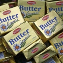 Viele Pakete Butter liegen auf einem Haufen.