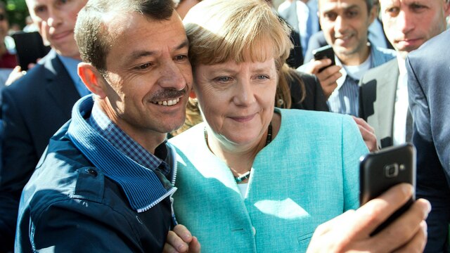 Mann macht Selfie mit Bundeskanzlerin Angela Merkel und sich