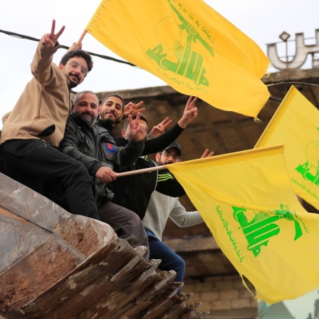 Männer, die in der Schaufel eines Bulldozers sitzen, schwenken Hisbollah-Fahnen, während sie die Waffenruhe zwischen Israel und der Hisbollah feiern, die am Mittwoch (27.11.2024) begonnen hat.