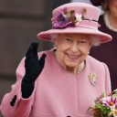 Die britische Königin Elizabeth II. hält einen Blumenstrauß in der Hand und winkt
