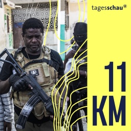 Der oberste haitianische BandenführerJimmy Chérizier, auch bekannt unter dem Namen Barbecue, mit Waffe zwischen mehreren vermummten Männern. 