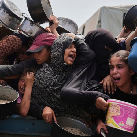 Palästinensische Kinder erhalten gespendete Lebensmittel in einem Verteilungszentrum in Chan Junis, Gazastreifen.