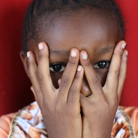 Afrikanisches Mädchen hält sich die Hände vors Gesicht: Sexualisierte Gewalt bleibt eine Kriegswaffe. Überlebende Frauen in Bosnien oder Ruanda leiden bis heute unter Ausgrenzung - so wie die Kinder aus den Vergewaltigungen.
