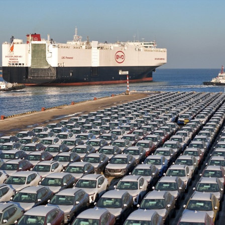 Ein Frachtschiff der chinesischen E-Auto-Marke BYD fährt aus dem Hafen. Es ist mit E-Autos beladen. 