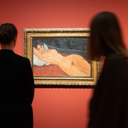 Zwei Frauen stehen während eines Pressetermins vor dem Gemälde &#034;Liegender Frauenakt mit weißem Kissen&#034; aus dem Jahr 1917 von Amedeo Modigliani.