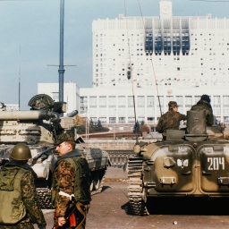 Eine Aufnahme von 1993 zeigt Soldaten vor der Rückansicht zweier Panzer vor einem hohen weißen Gebäude.