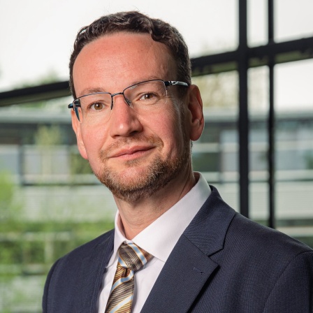 Ein Mann mit Brille schaut in die Kamera