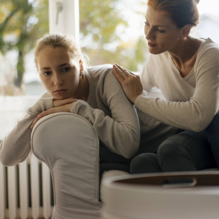 Eine Mutter tröstet ihre Tochter im Teenager-Alter