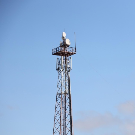 Telekommunikations-Antennen-Turm mit 4G und 5G vor einem blauen Himmel.