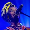 Die malische Sängerin Fatoumata Diawara lächelnd vor einem Mikrofon
