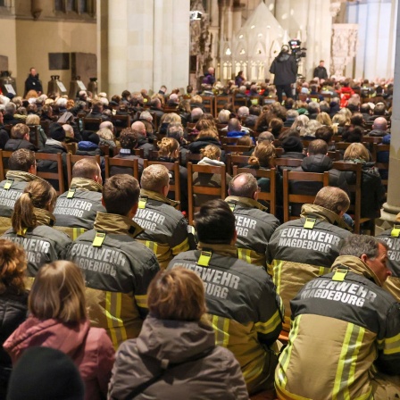 Einsatzkräfte der Feuerwehr sitzen in einer Gedenkveranstaltung im Magdeburger Dom. Am Vorabend war ein Autofahrer auf dem Magdeburger Weihnachtsmarkt in eine Menschengruppe gefahren.