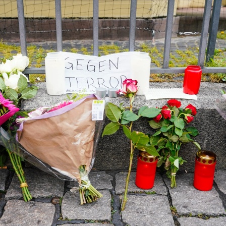 Kerzen, Blumen und ein Blatt Papier mit der Aufschrift "Gegen Terror" stehen am Tatort auf dem Marktplatz.