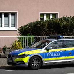 Ein Polizeiauto steht vor einem Wohnhaus