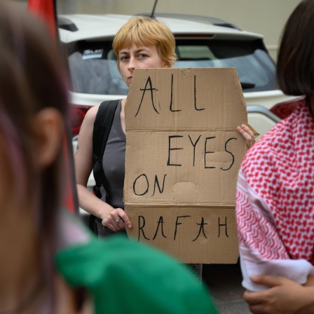 Ein junge Frau protestiert gegen den Krieg in Nahost mit einem Plakat auf dem "All eyes on Rafah" zu lesen ist.