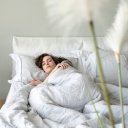 Eine junge Frau liegt im Bett und schläft friedlich