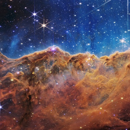 Diese Landschaft aus Bergen und Tälern, die mit glitzernden Sternen übersät ist, ist eigentlich der Rand einer nahe gelegenen, jungen Sternentstehungsregion namens NGC 3324 im Carina-Nebel. Das Bild wurde vom neuen James-Webb-Weltraumteleskop der NASA im Infrarotlicht aufgenommen.