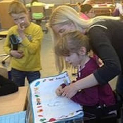 Eine Lehrerin hilft einer Schülerin in der Körperbehindertenschule in Kronau
