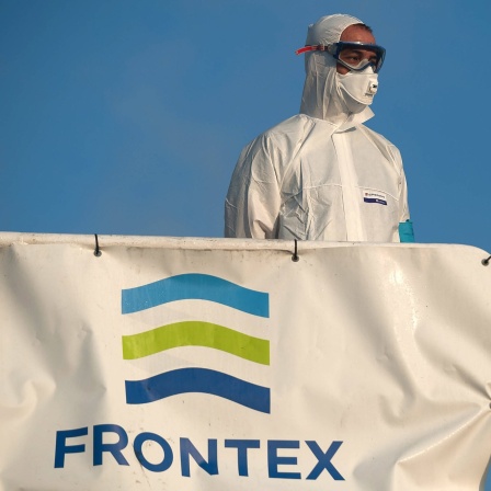 Ein Mitglied der Europäischen Grenz- und Küstenwache Frontex in einen Schutzanzug auf einem Patrouillenschiff im Hafen von Malaga