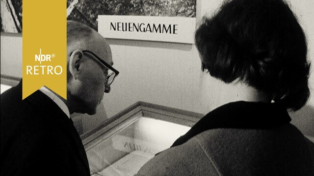 Besucher an einer Vitrine in einer Ausstellung übder das KZ Neuengamme (1965)