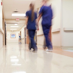 Symbolbild Pflege im Krankenhaus: Zwei Krankenhausmitarbeiter gehen über einen Flur.